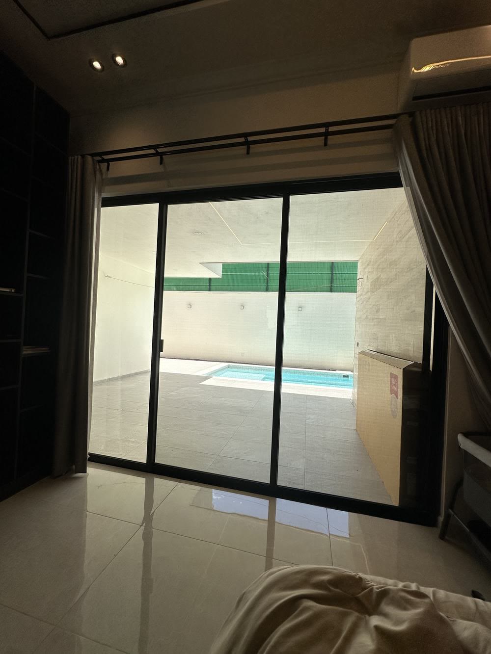 Sala con ventanal hacia la alberca con el sol de la tarde